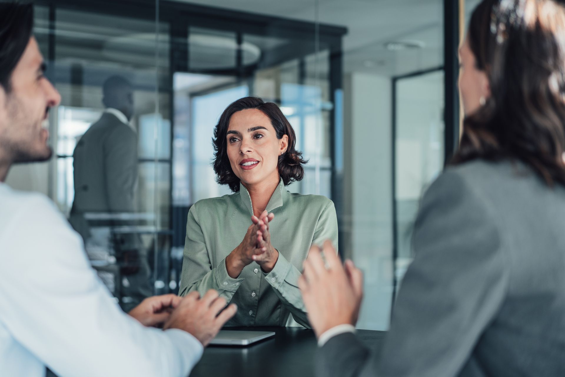 A group of people are sitting around a table having a meeting.