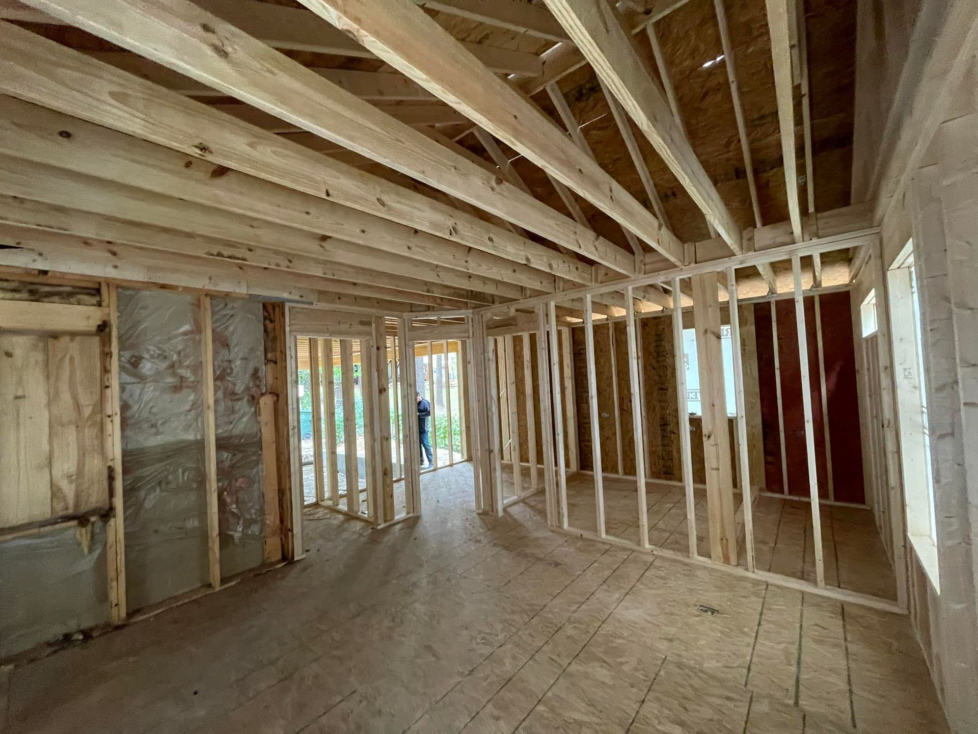 A room in a house under construction with wooden beams.