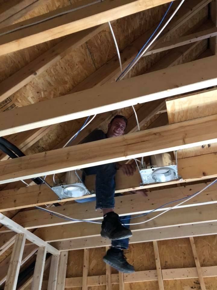 A man is sitting on the ceiling of a building under construction.