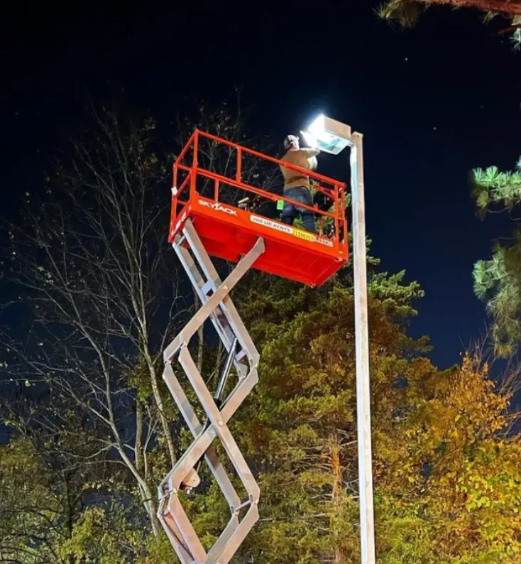 A man on a scissor lift working on a street light