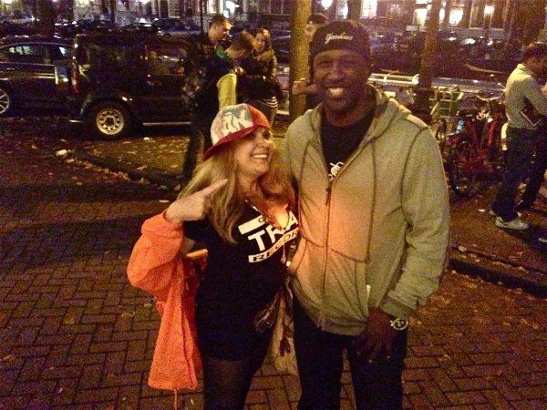 A man and a woman are posing for a picture on a brick sidewalk