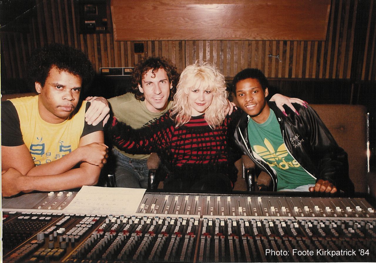 A group of people posing for a photo in front of a mixer