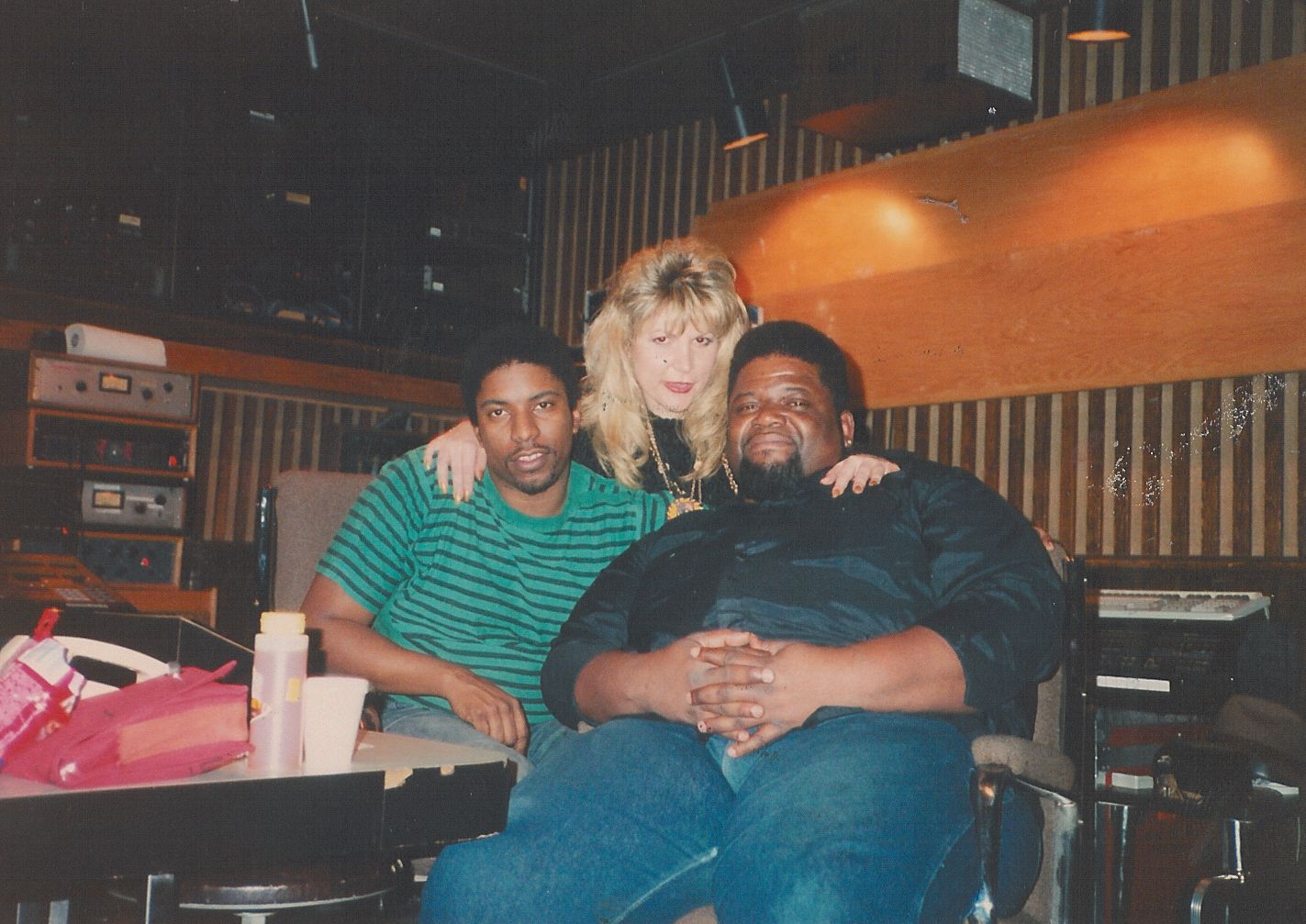 A man in a green striped shirt sits with two other people