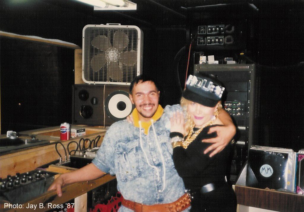 A man and a woman pose for a photo in front of a stereo