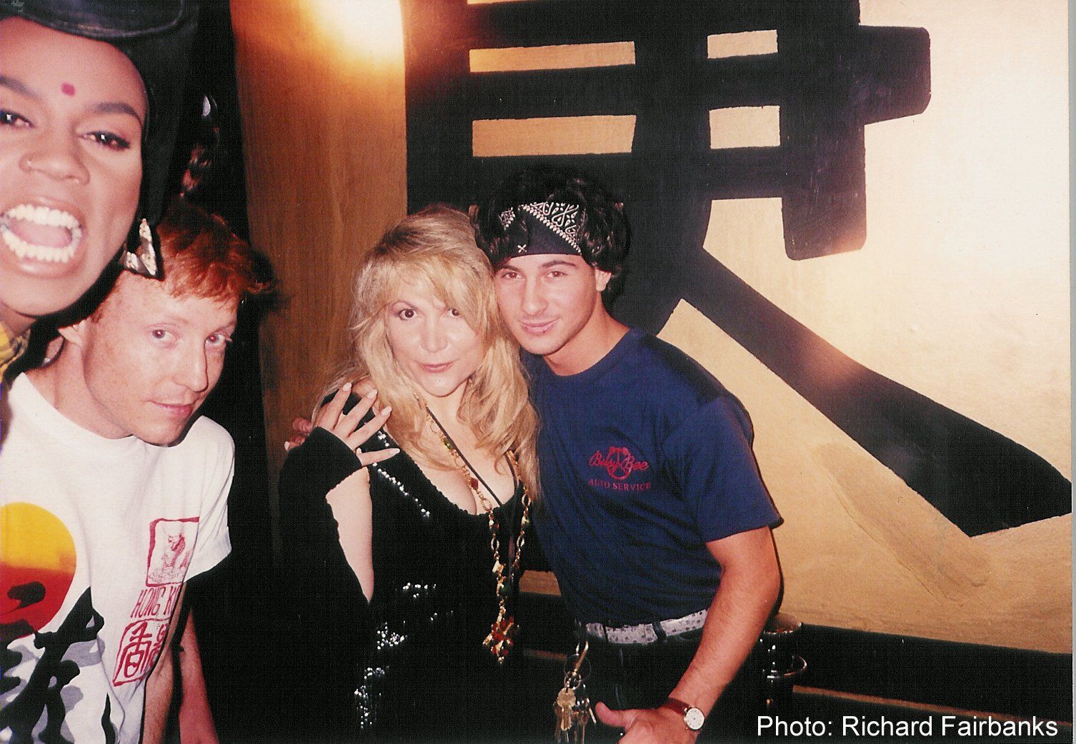 A group of people posing for a photo with a chinese symbol in the background
