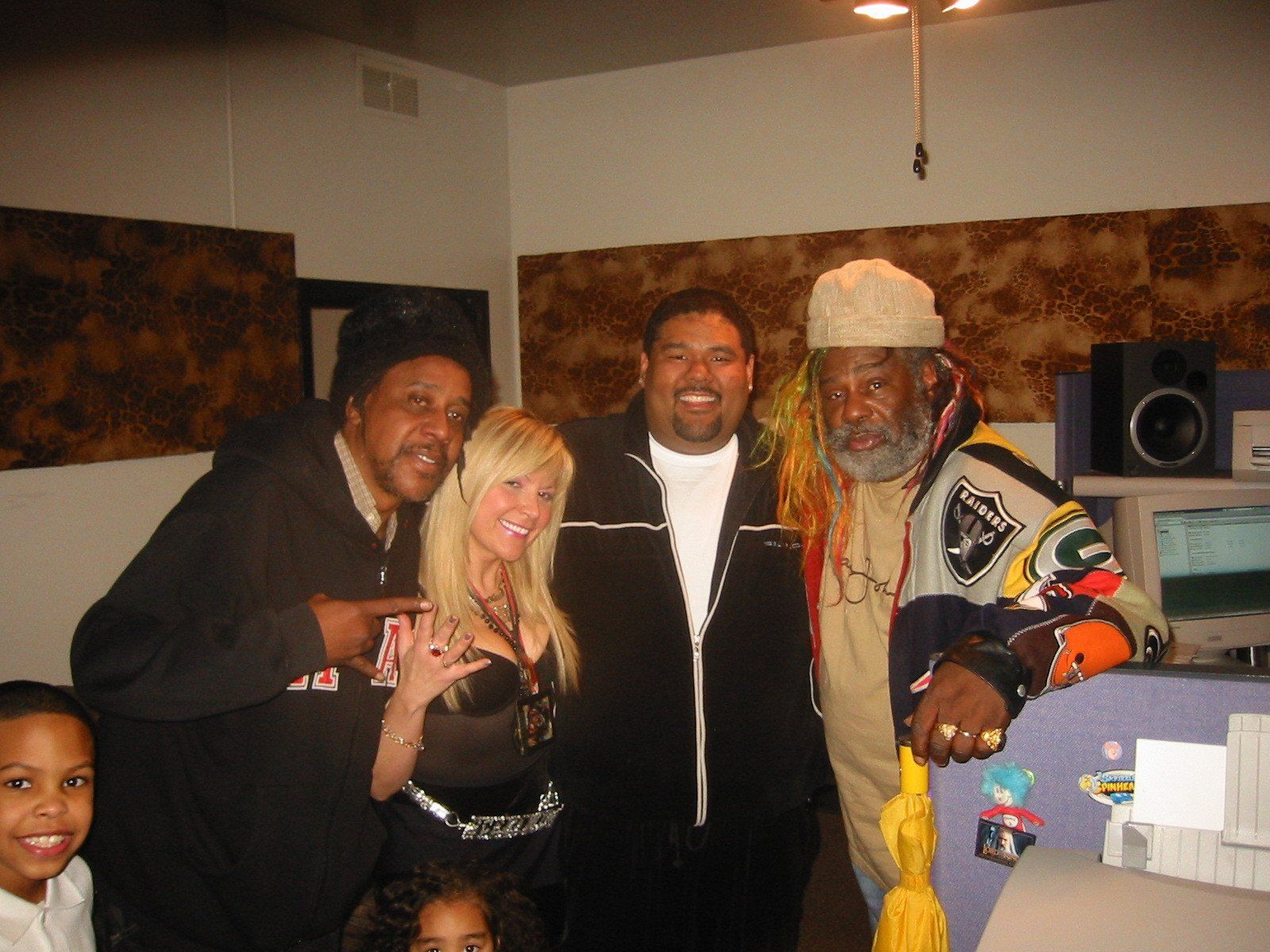 A group of people posing for a picture with one man wearing a jacket that says everlast