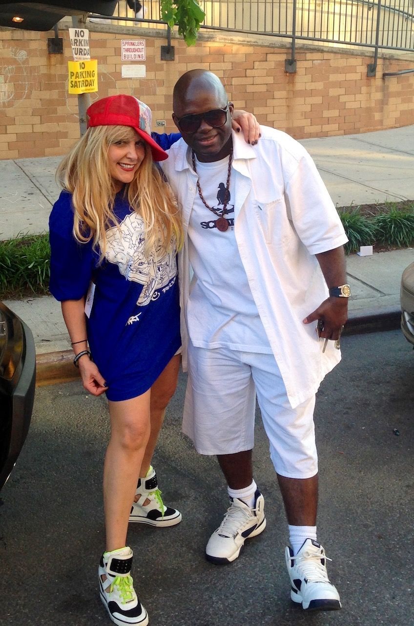 A man and a woman are posing for a picture in front of a no parking sign