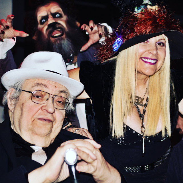 A group of people are posing for a picture and one of them is wearing a hat with the letter e on it