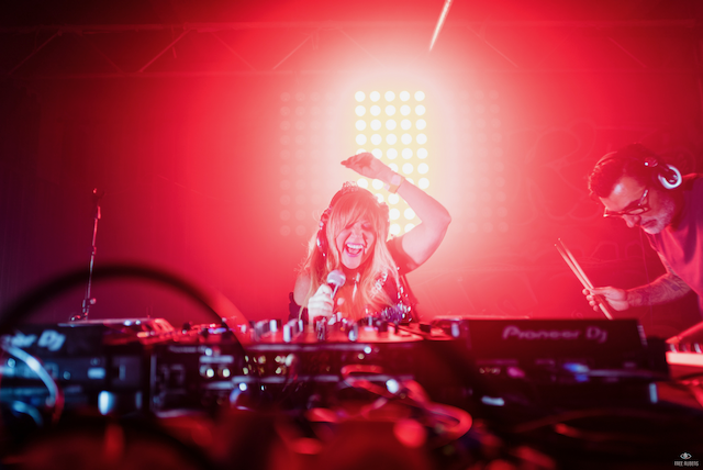 A man and a woman are playing music on a stage.