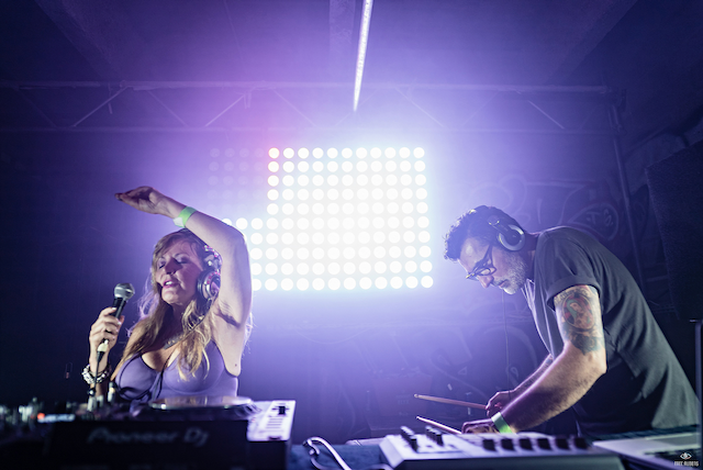A man and a woman are playing music on a stage.
