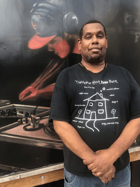 A man wearing a black shirt with a house on it