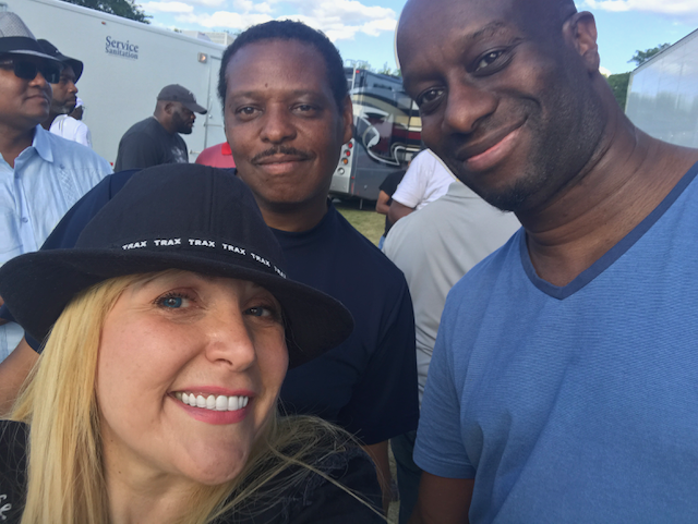 A group of people posing for a picture including a woman wearing a hat