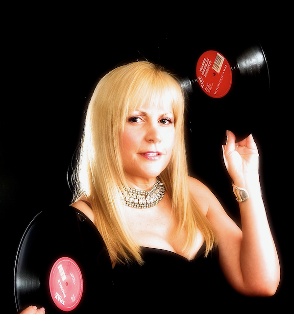 A woman in a black dress is holding two vinyl records