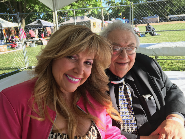 A man and a woman are posing for a picture in a park