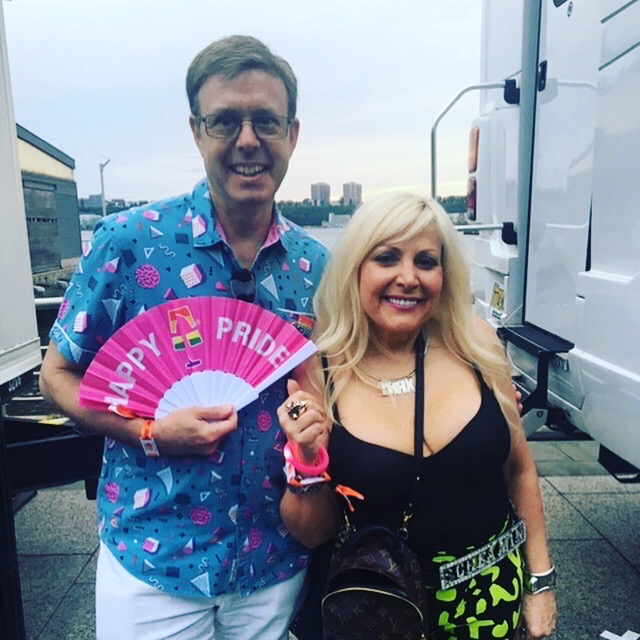 A man is holding a pink fan that says happy pride