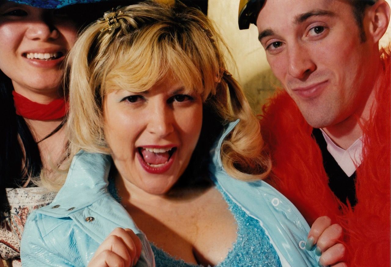 A group of people are posing for a picture and one of them is wearing a blue jacket