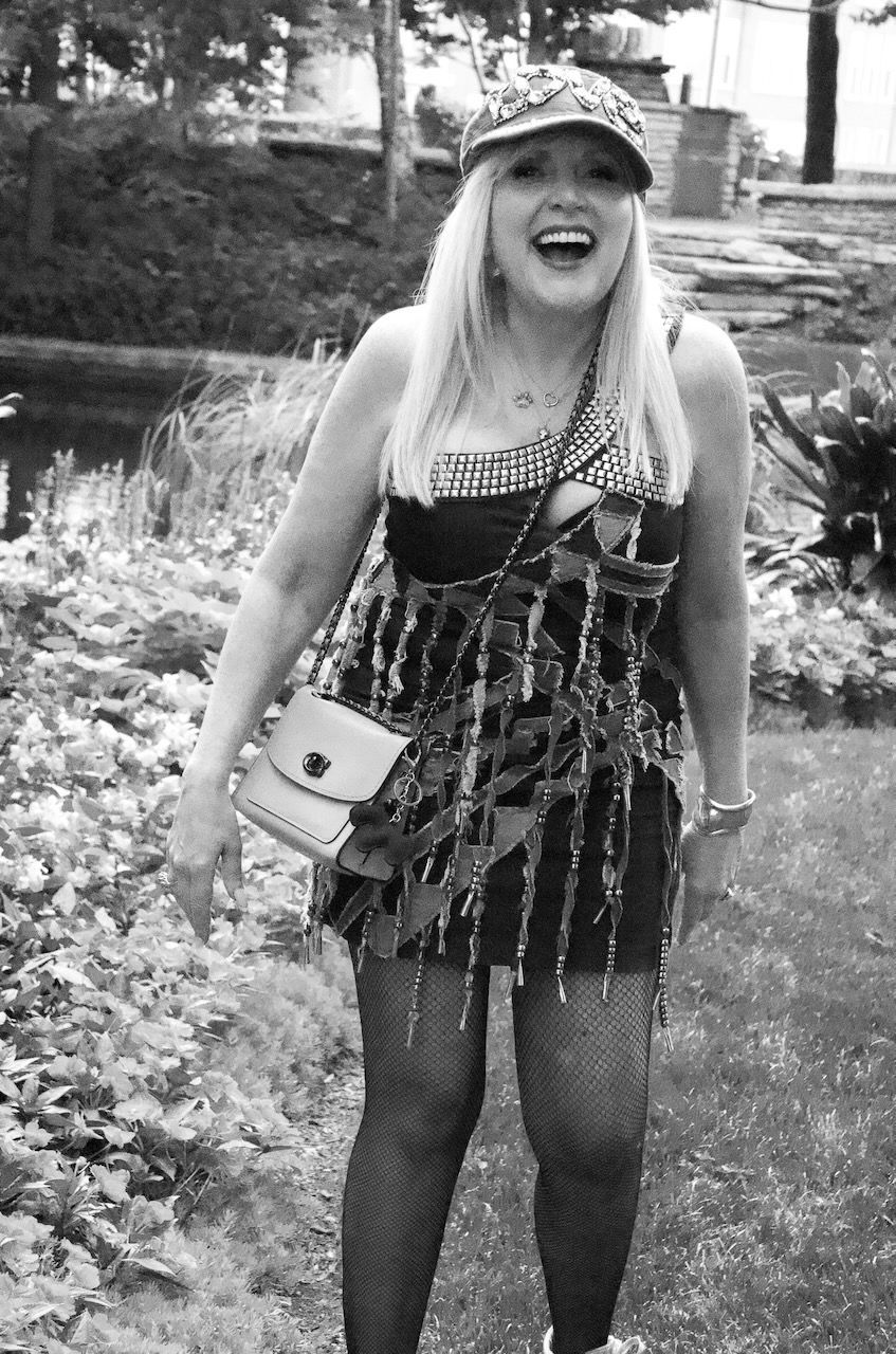 A black and white photo of a woman wearing a hat and a dress