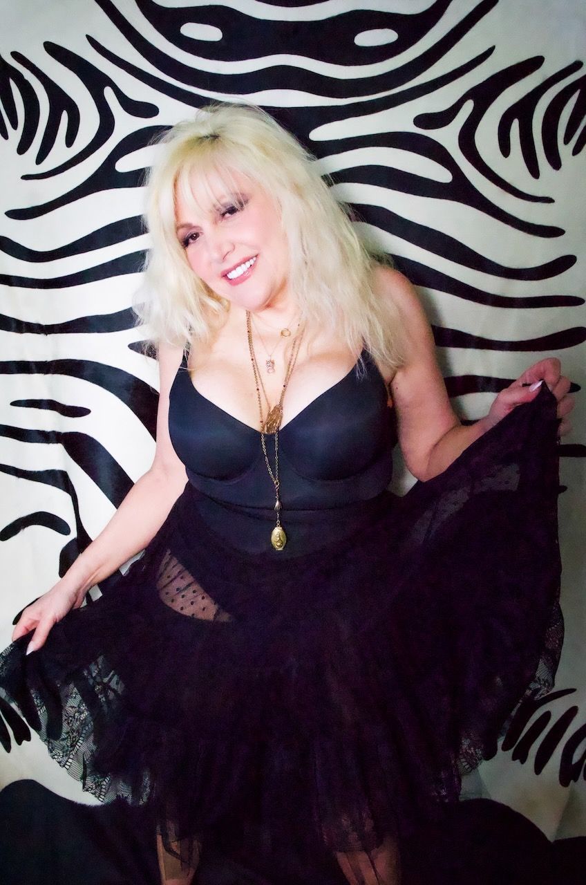 A woman in a black dress is standing in front of a zebra print wall