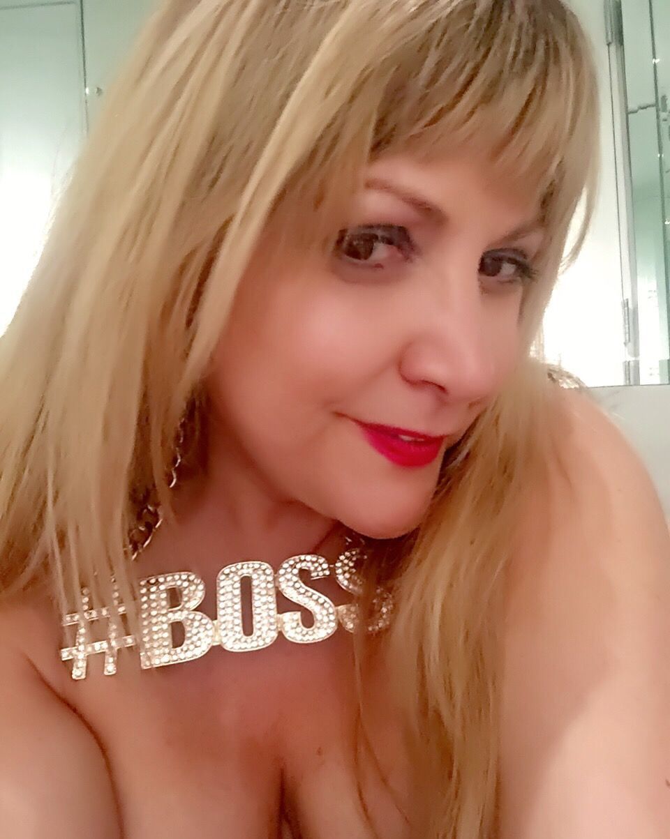 A woman wearing a necklace with the word boss on it
