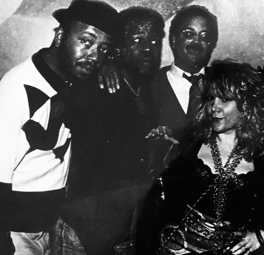 A black and white photo of a group of people posing for a picture