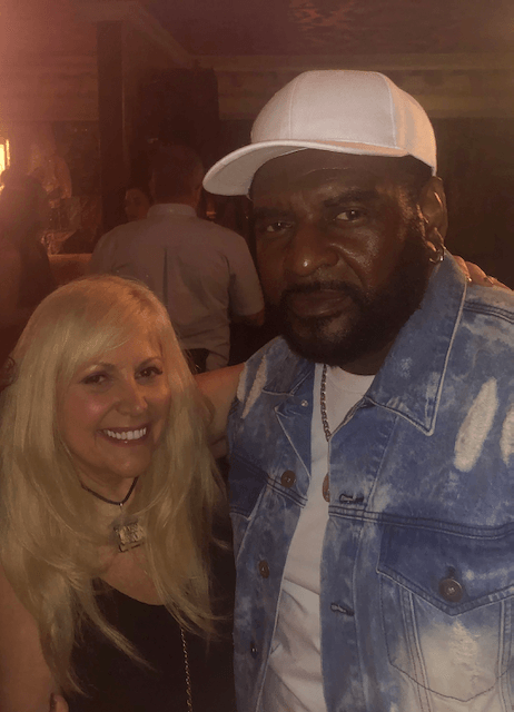 A man and a woman are posing for a picture in a dark room.