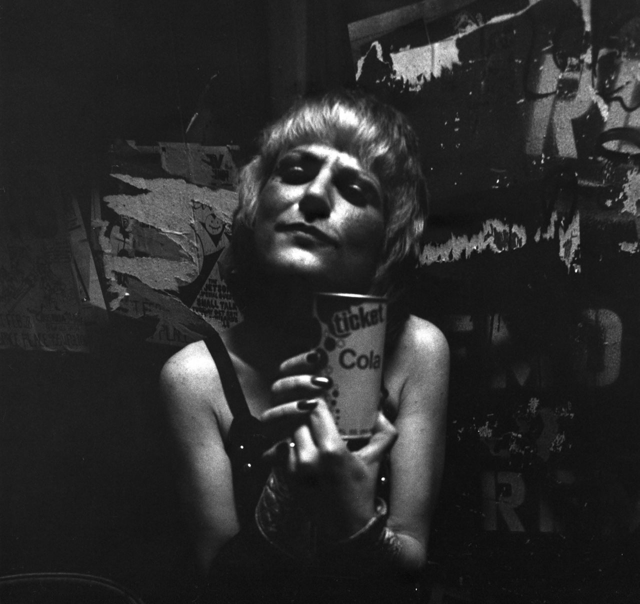 A black and white photo of a woman holding a can of soda