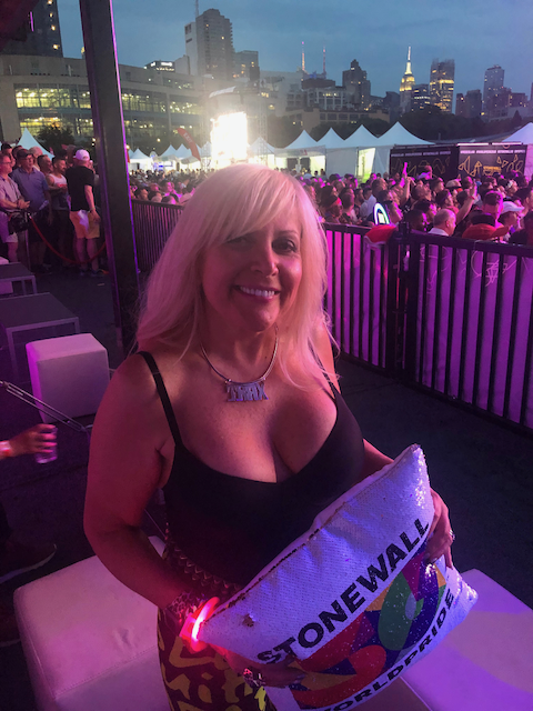 A woman is holding a pillow that says stonewall