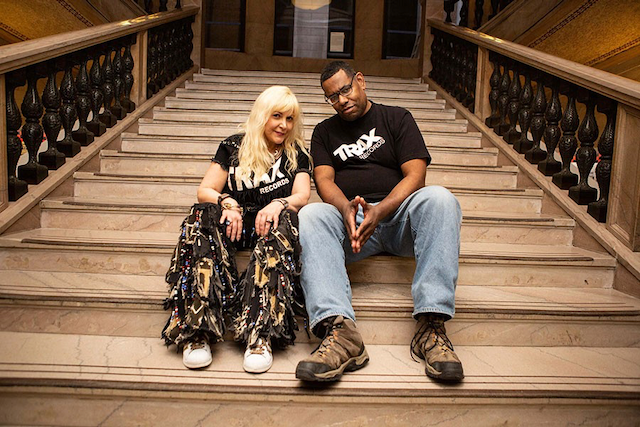 A man and a woman are sitting on a set of stairs.