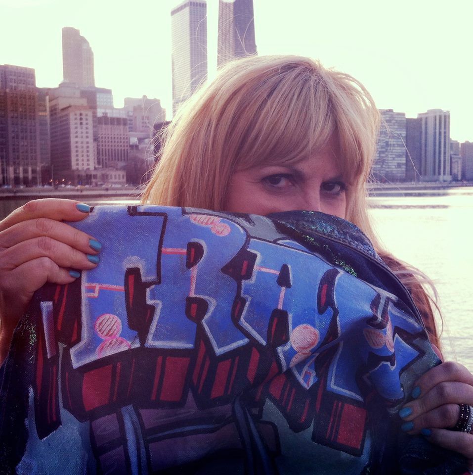 A woman covering her face while holding a piece of graffiti that says free