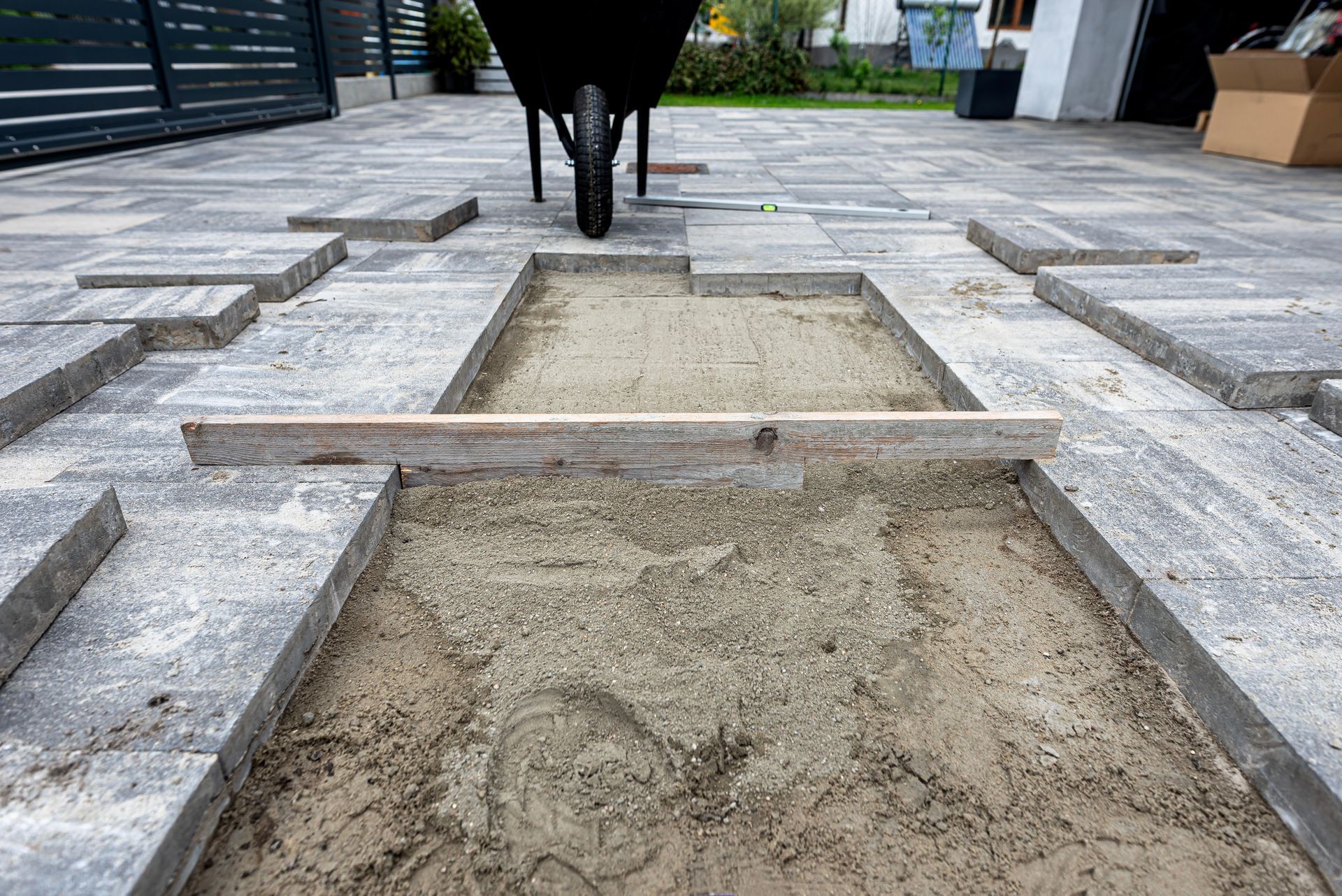 Gravel pathway with rectangular stepping stones and a wheelbarrow in the background. Gravel pathway with rectangular stepping stones and a wheelbarrow in the background.