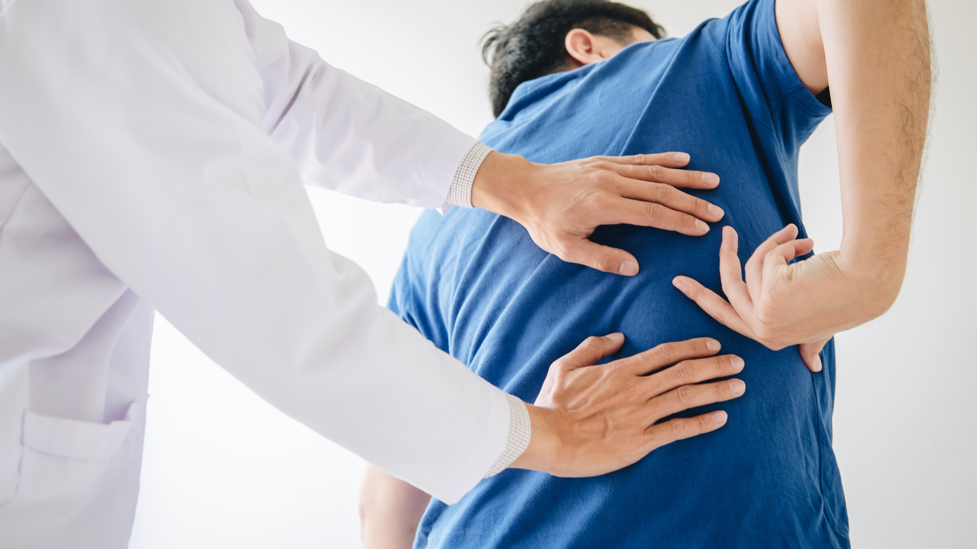 A man is getting his back examined by a doctor.