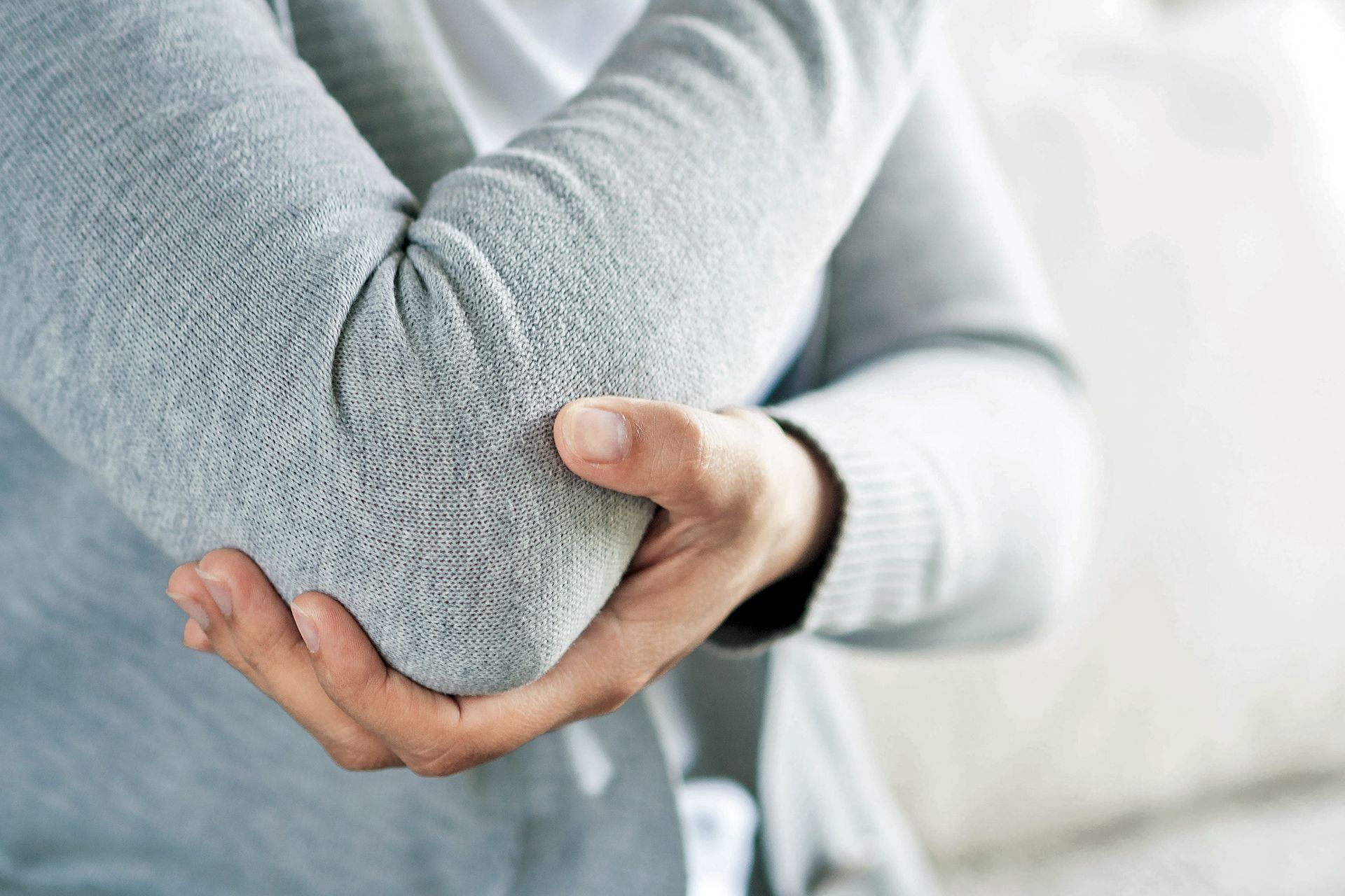 patient holding elbow