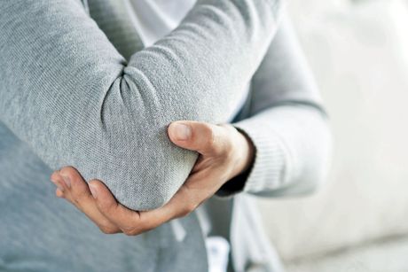 patient holding elbow