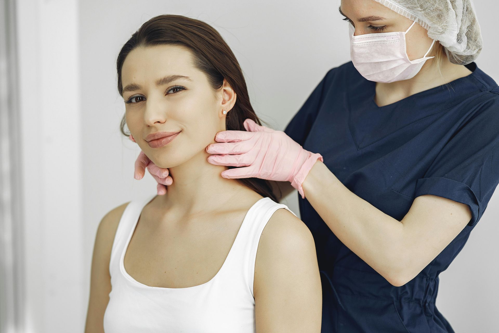 A woman is getting her neck examined by a doctor.