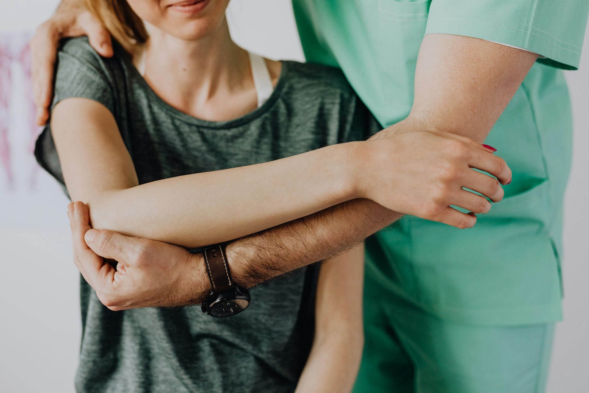 A man is holding a woman 's arm while she is sitting down.