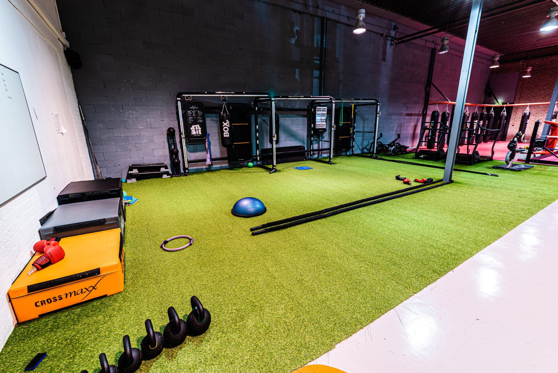 Een grote fitnessruimte met veel apparatuur op de vloer.
