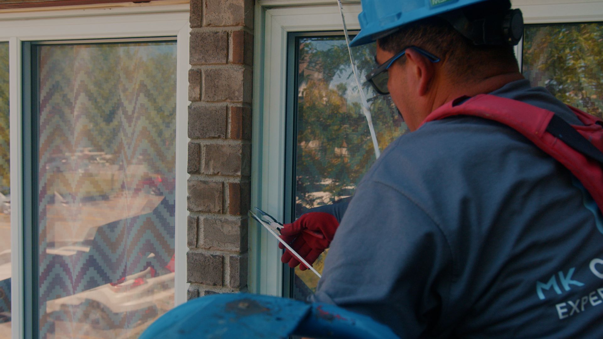 Un homme portant un casque travaille sur une fenêtre.