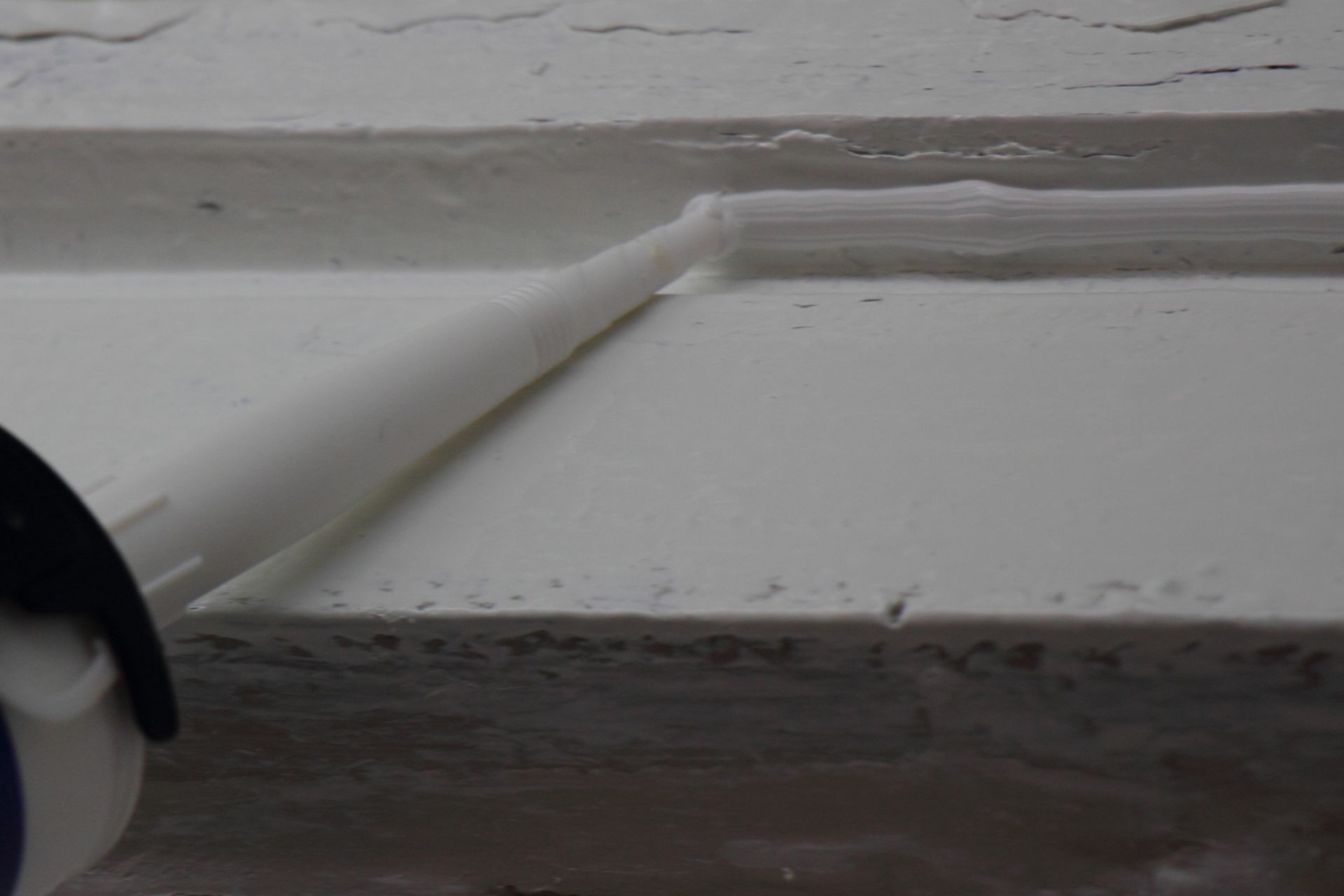 Un gros plan d'une surface blanche avec une paille qui en sort.