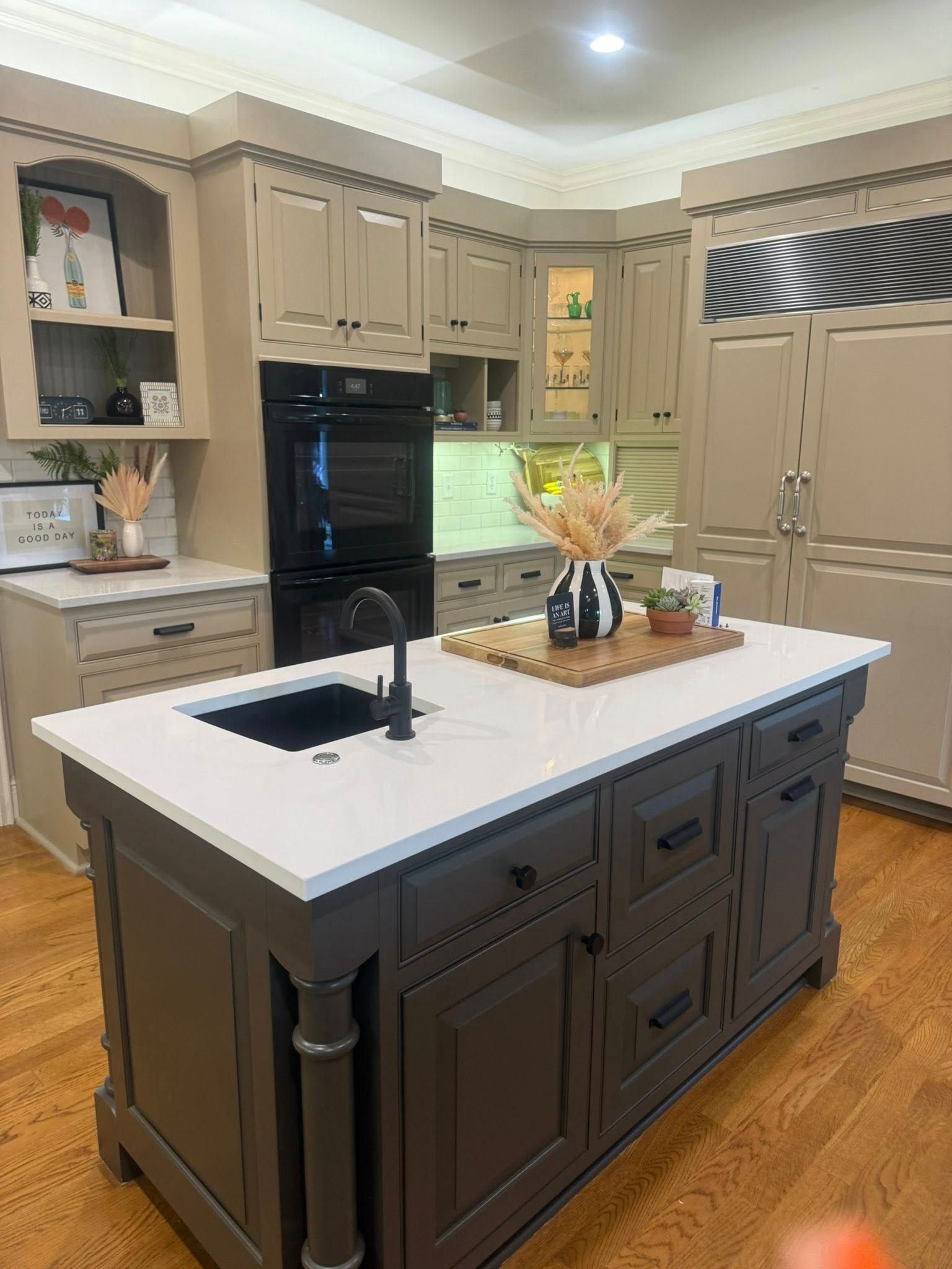 Modern kitchen with white upper cabinets, dark blue base cabinets, and marble countertops.