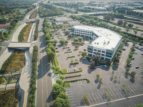 An aerial view of a large building with a parking lot in front of it