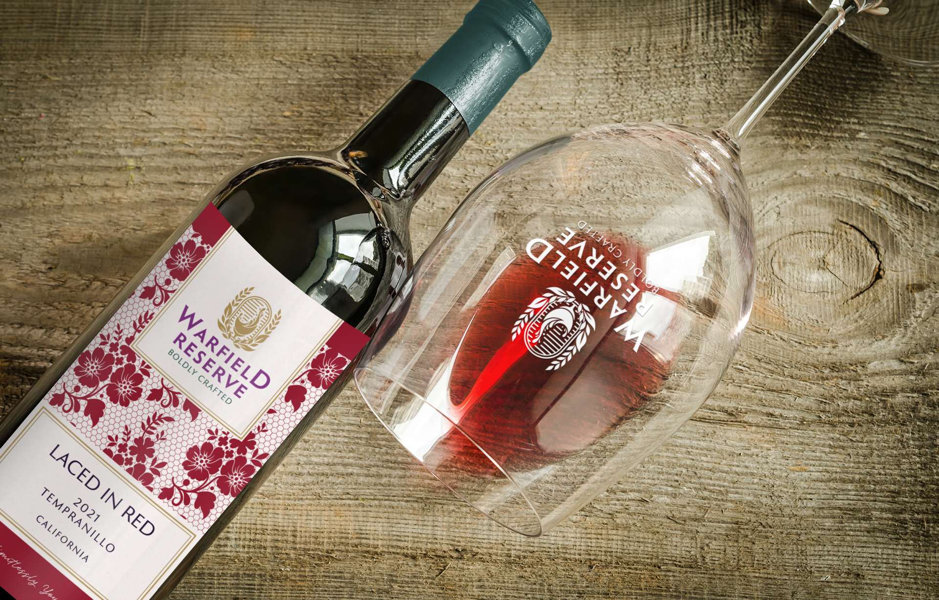 Wine bottle and glass with red wine on a wooden surface. Label reads "Warfield Reserve".