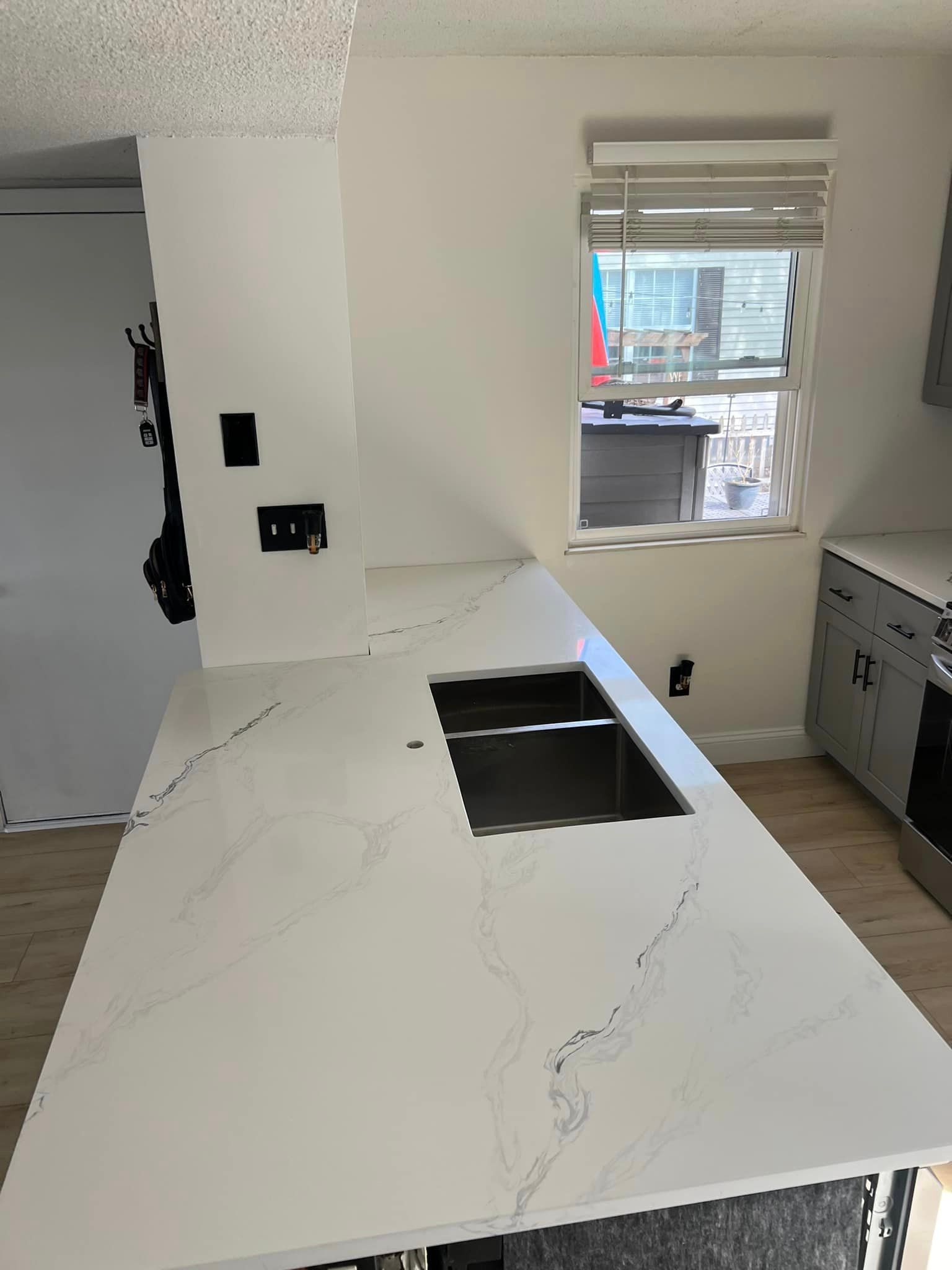 A kitchen with a white counter top and a sink.