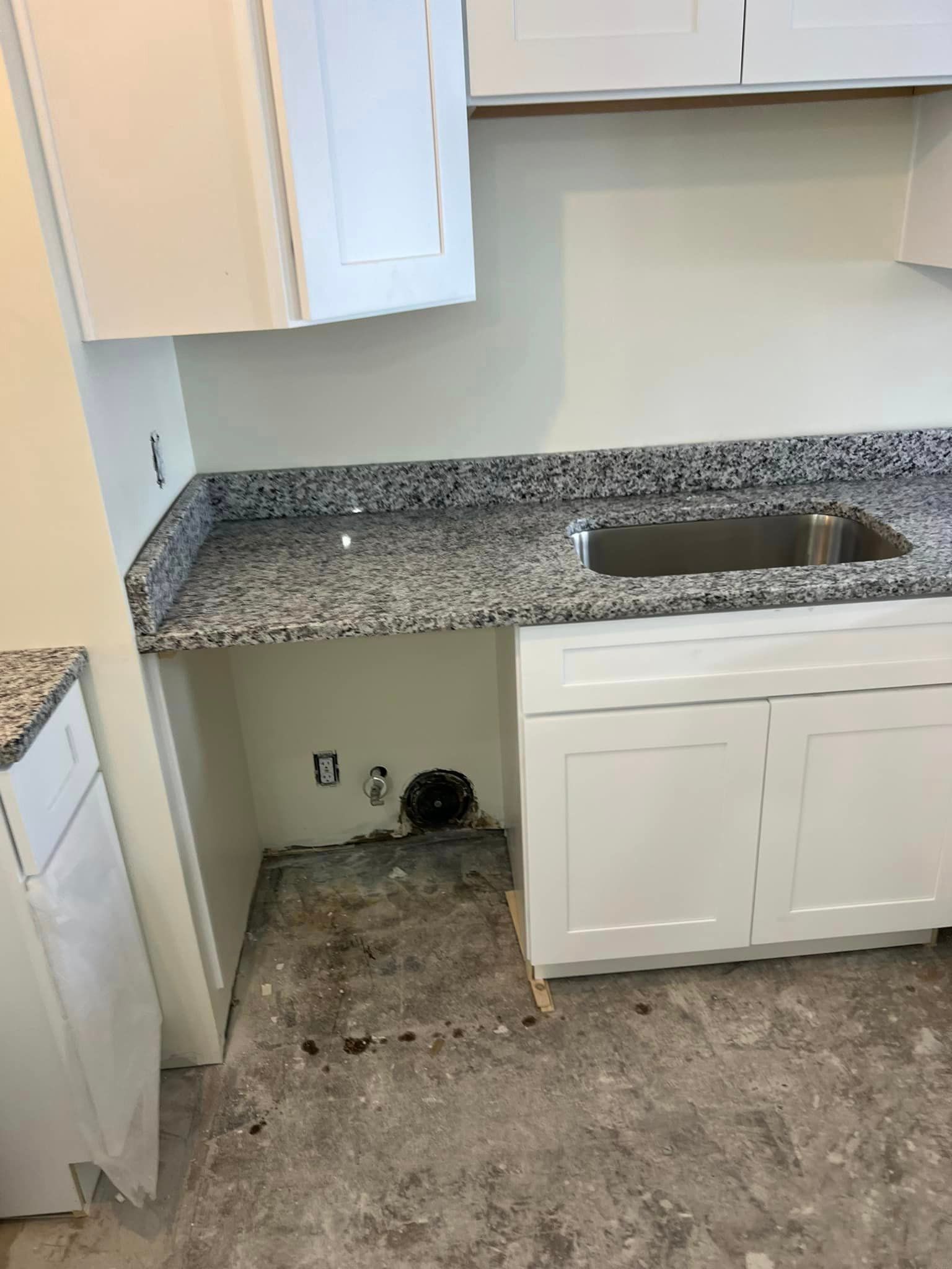 A kitchen with granite counter tops and a sink.