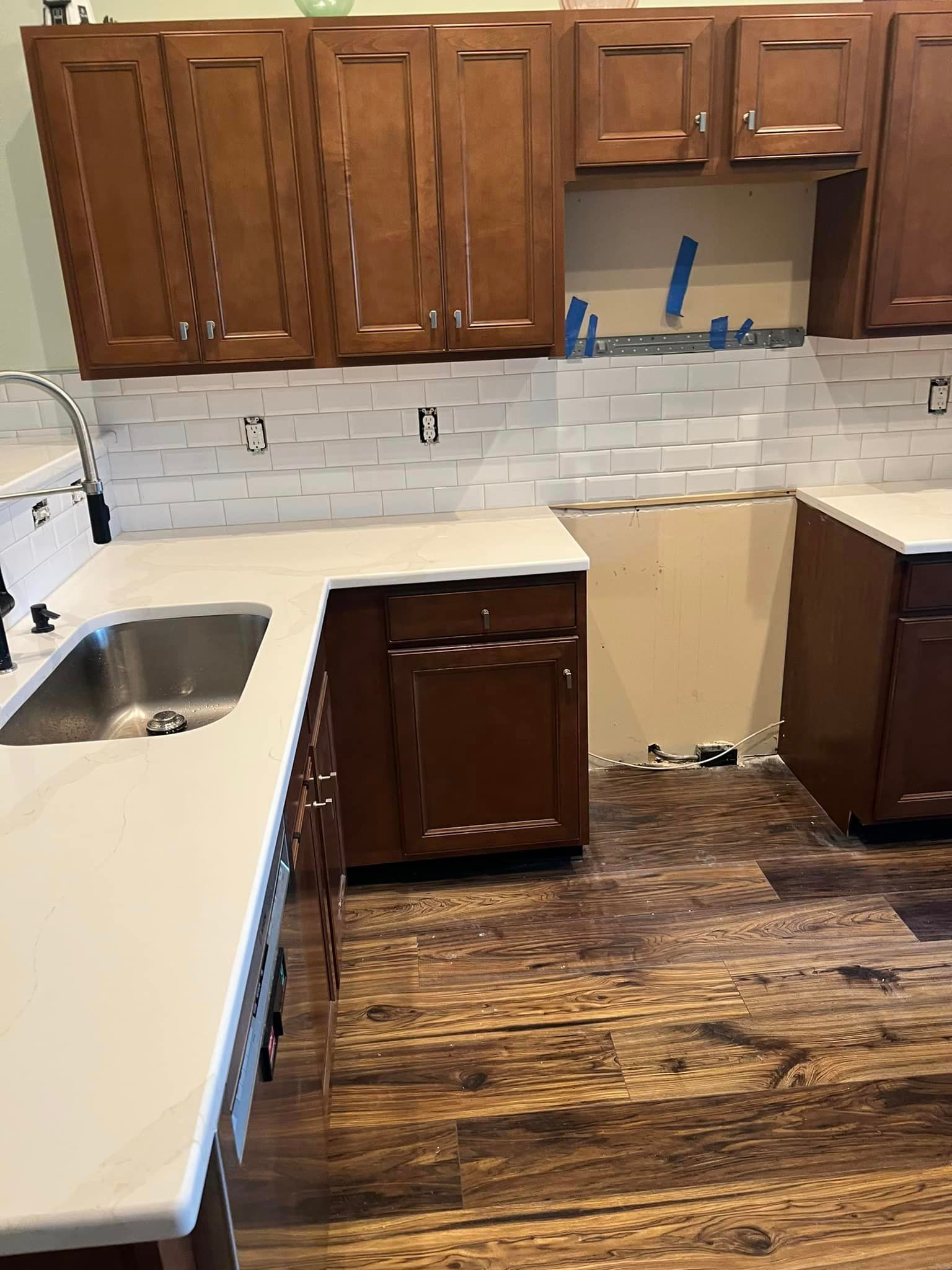 A kitchen with wooden cabinets and a sink.