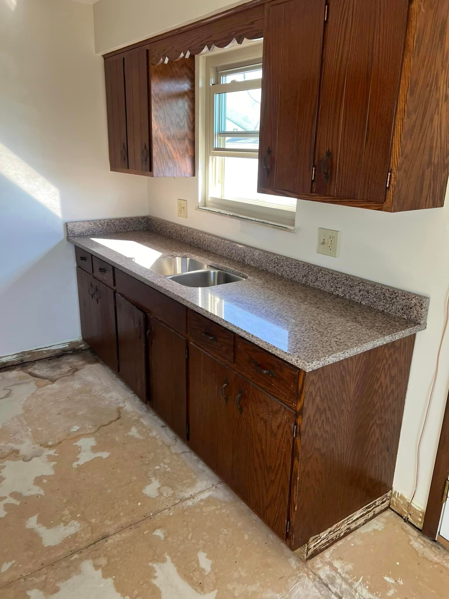 A kitchen with wooden cabinets and granite counter tops.