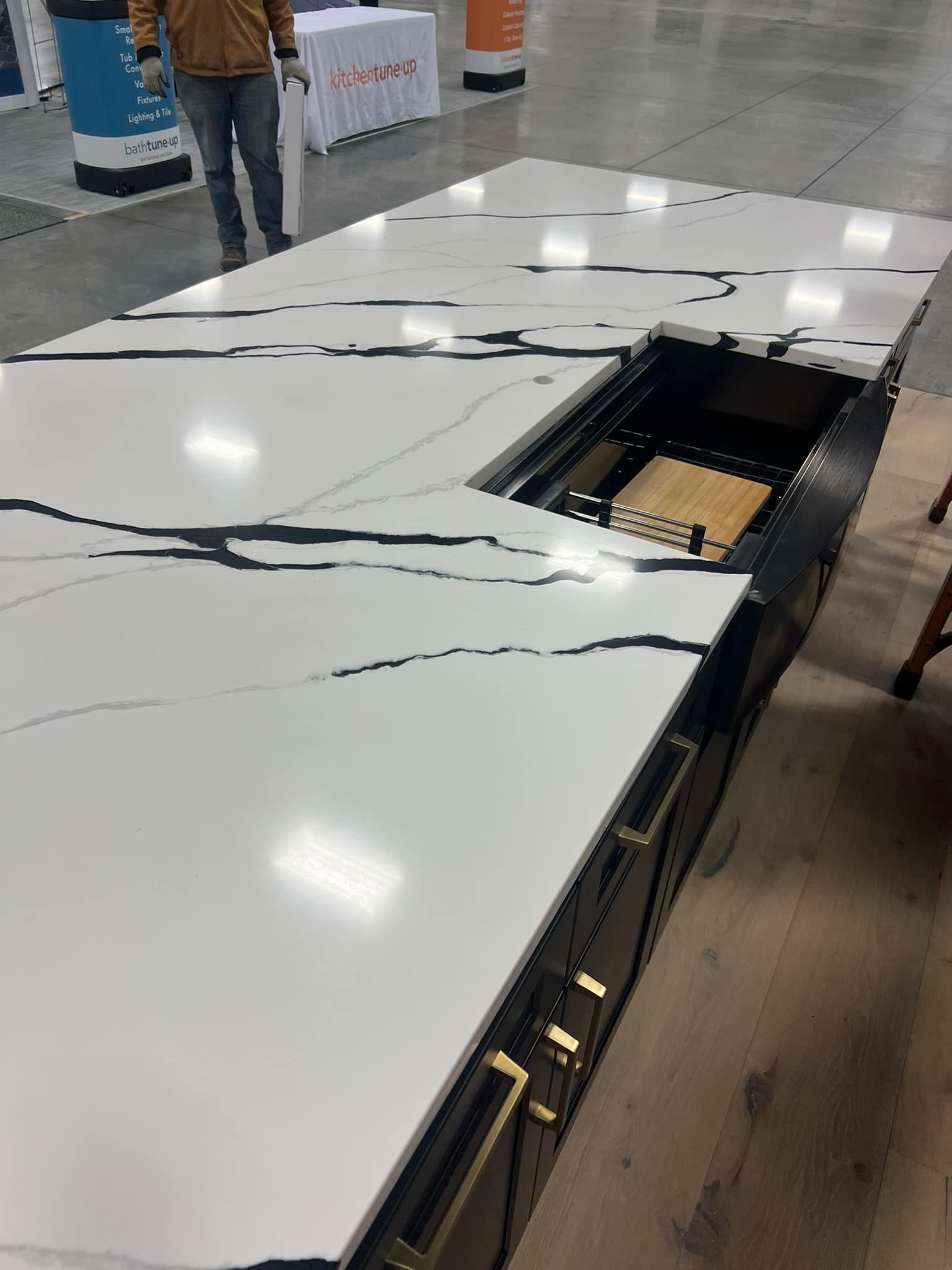 A man is standing next to a large white counter top.