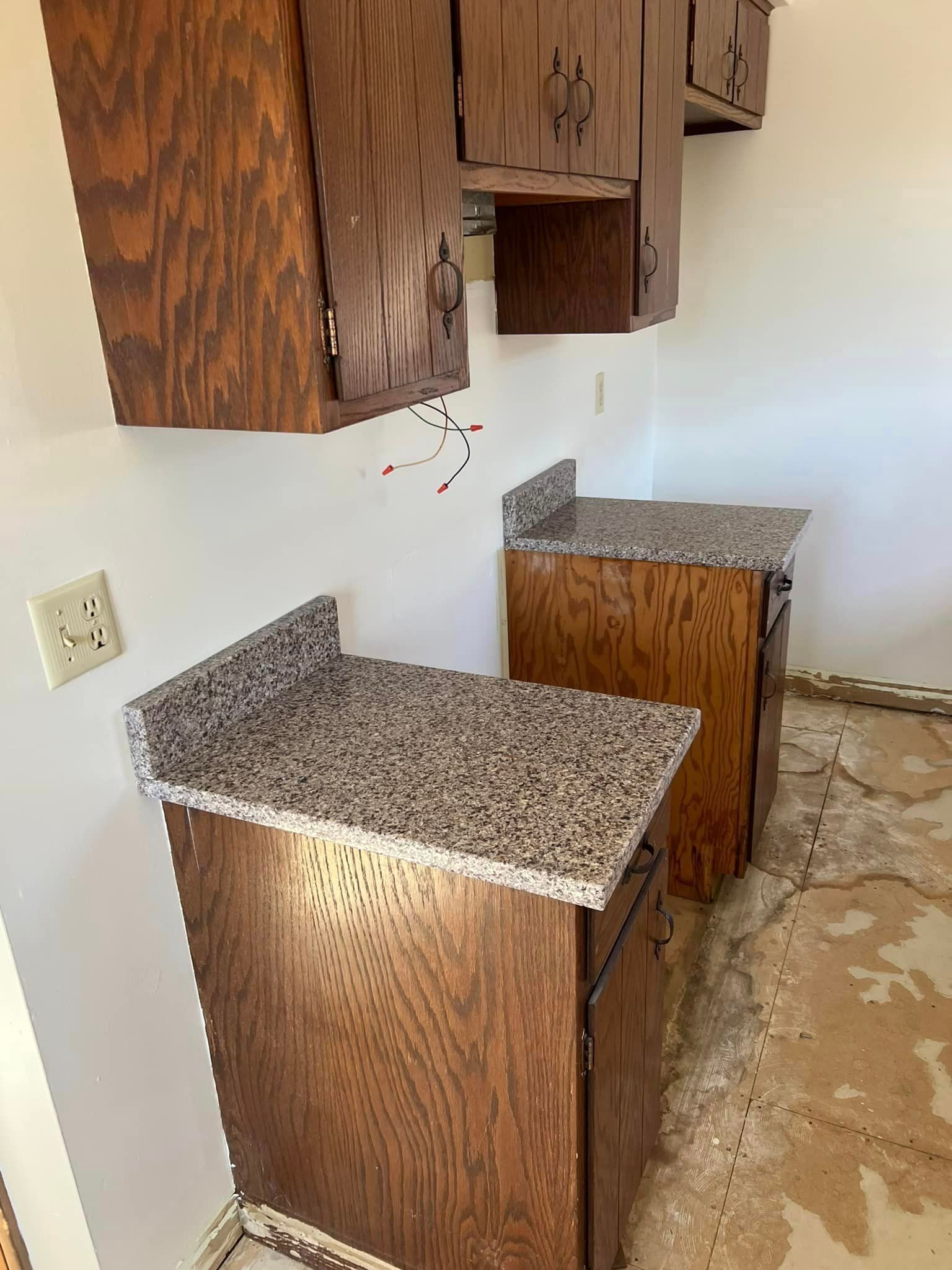 A kitchen with wooden cabinets and granite counter tops.