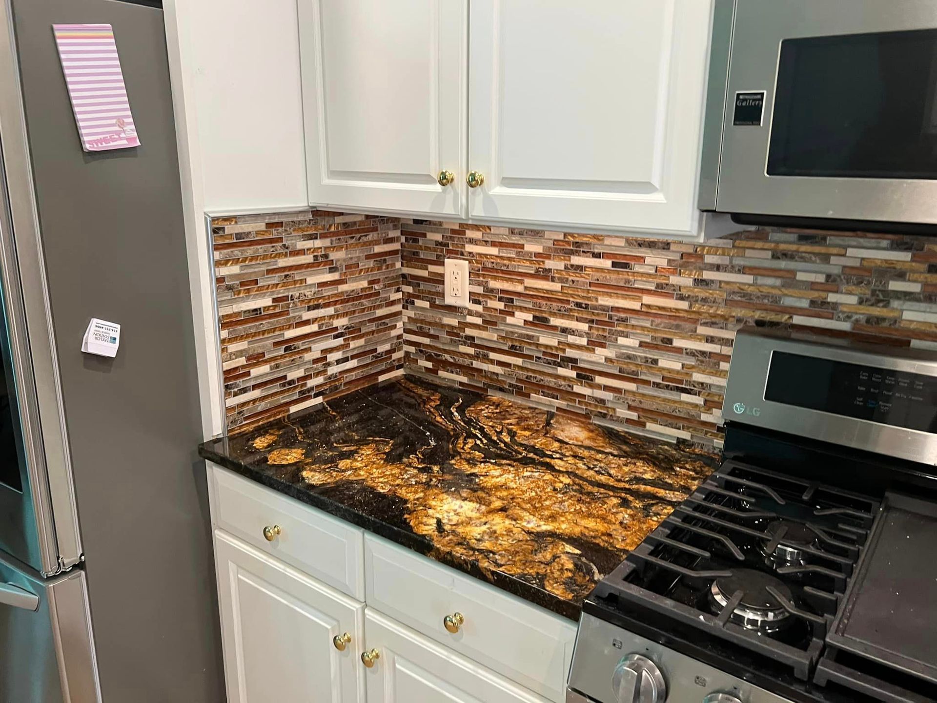 A kitchen with a stove , microwave and refrigerator.