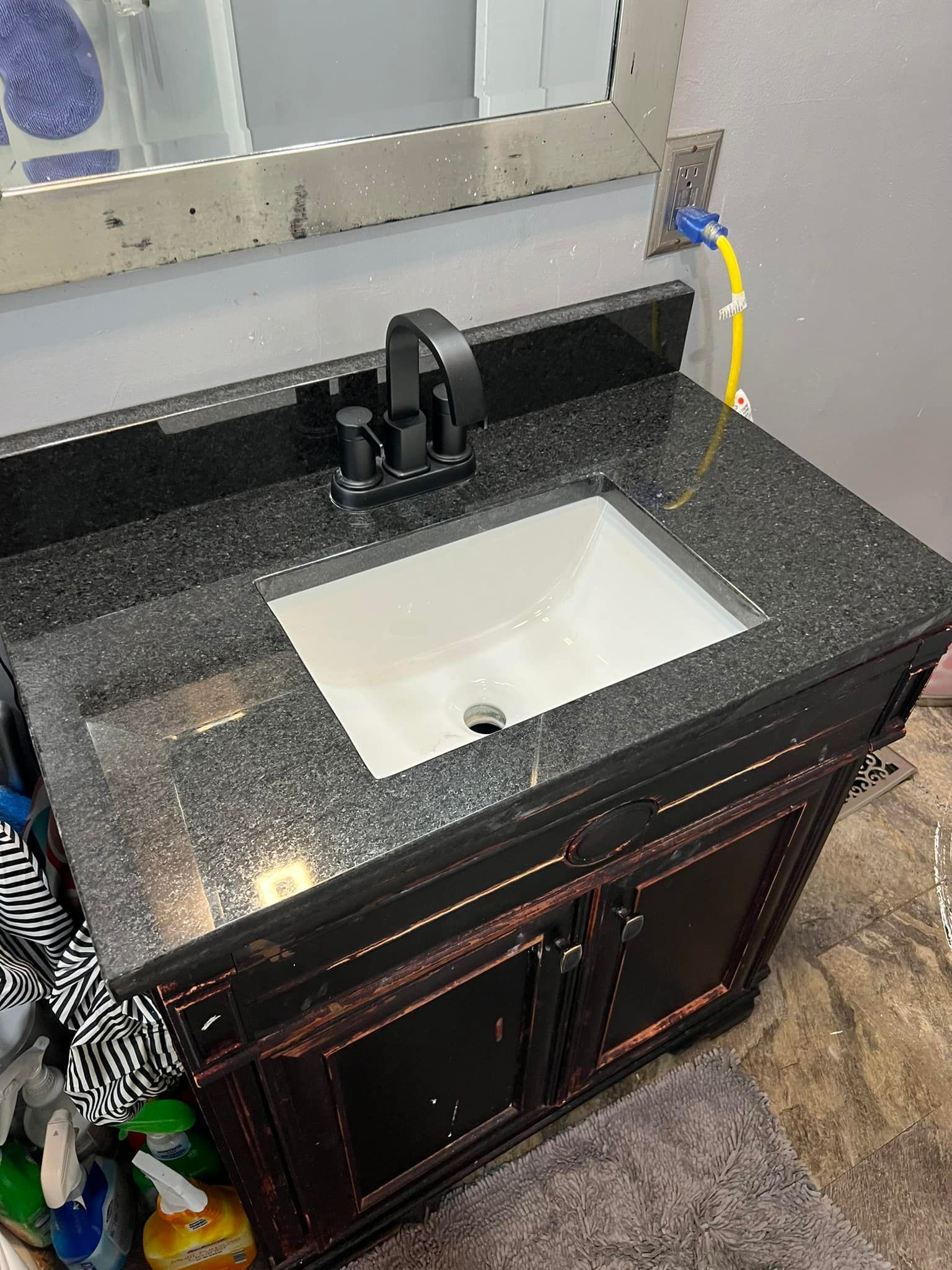 A bathroom vanity with a sink , faucet and mirror.