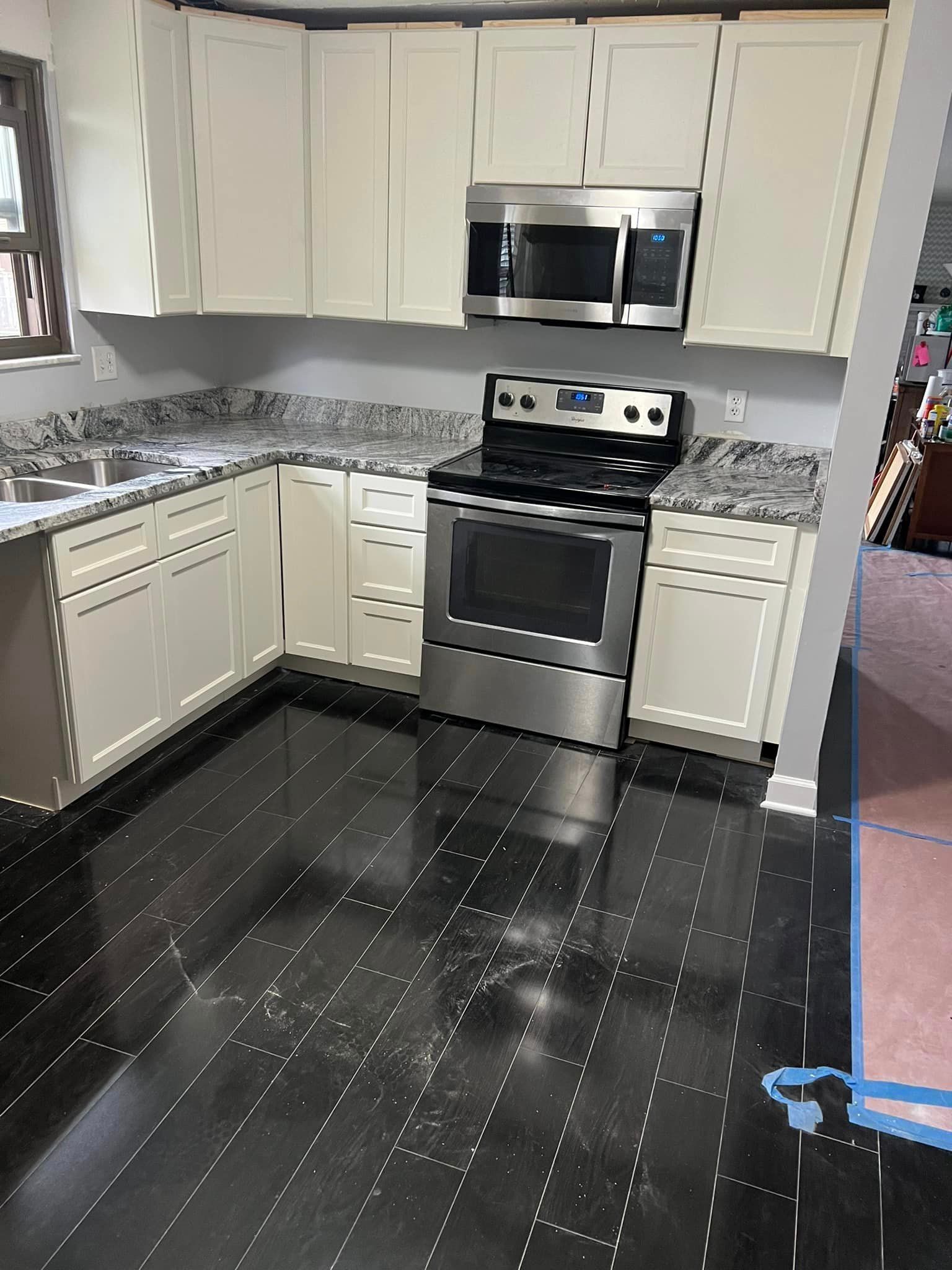 A kitchen with white cabinets and stainless steel appliances